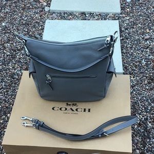 It is a brand new Gray Coach leather bag With cross body attachment.
